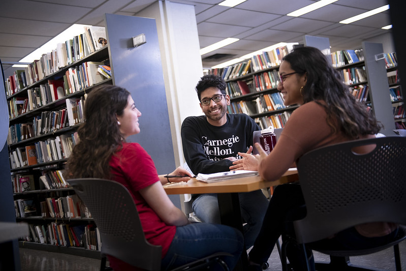 Three students at a table in the library