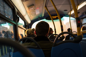 Image inside a bus, and the backs of passengers heads
