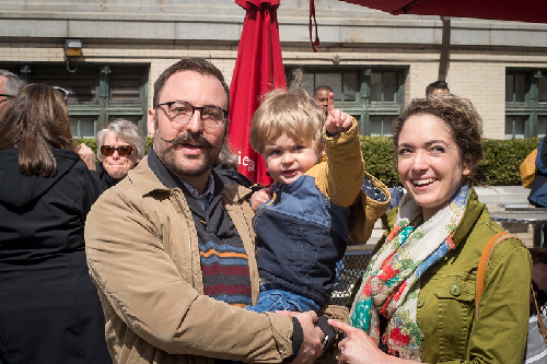 Parents hold their small child at a CMU community event