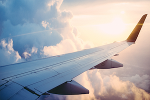 Image of a plane wing and clouds in the sky