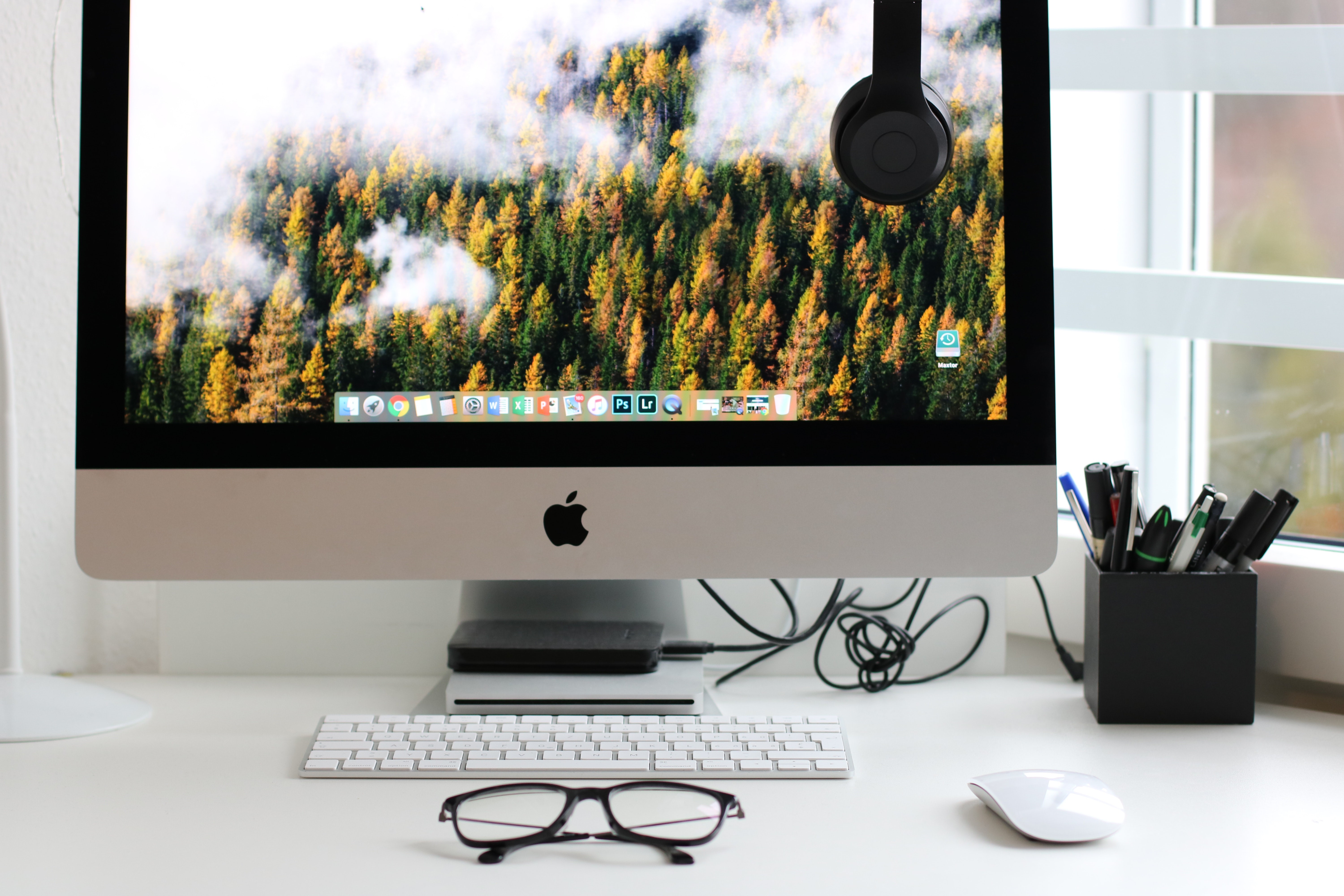 Mac computer with glasses sitting in front.