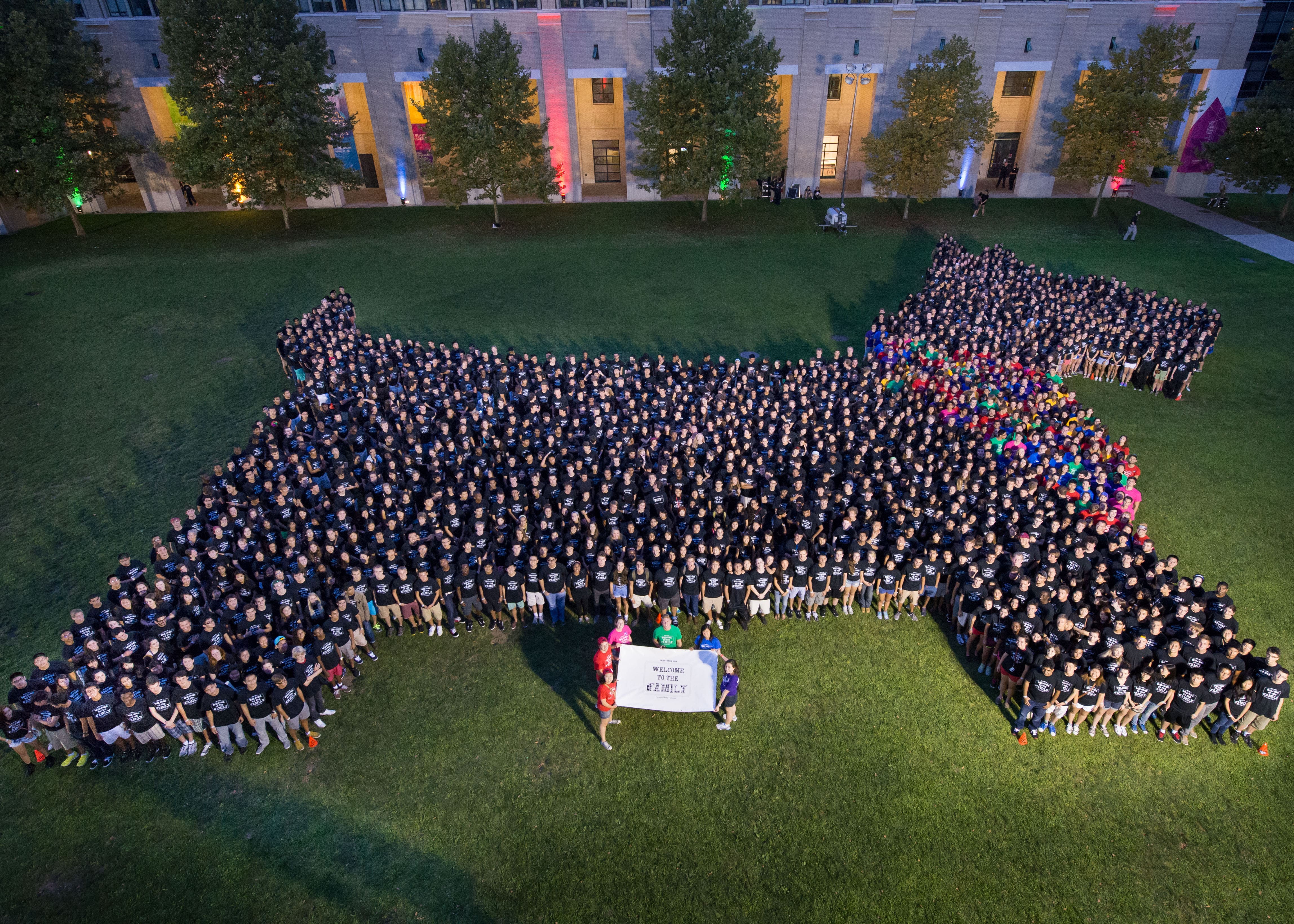 Aerial photo of hundreds of students standing on a field in the pattern of a Scottie dog
