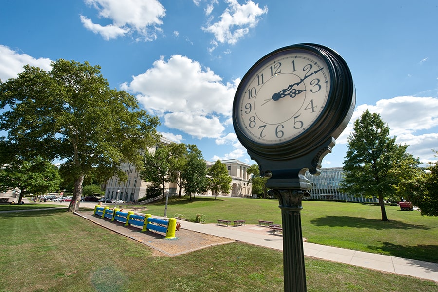 CMU campus with bright blue sky, clock and The Fence
