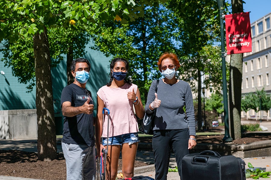 a CMU student with family members and suitcases