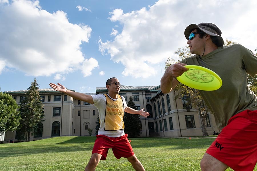 photo of two students playing frisbee