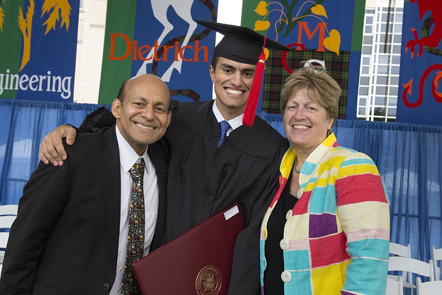 Photo of a smiling mother, father, and graduating senior at commencement