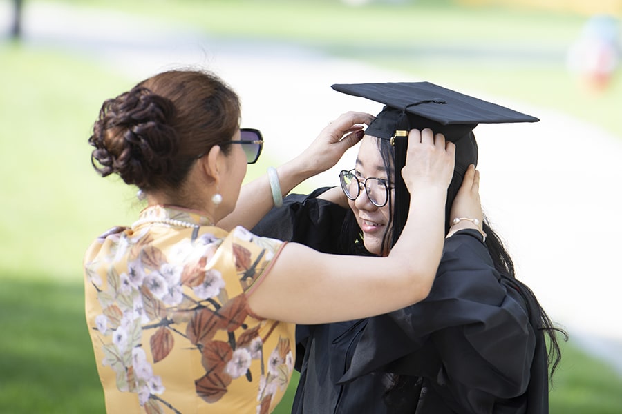 photo of a CMU student in cap and gown with her family