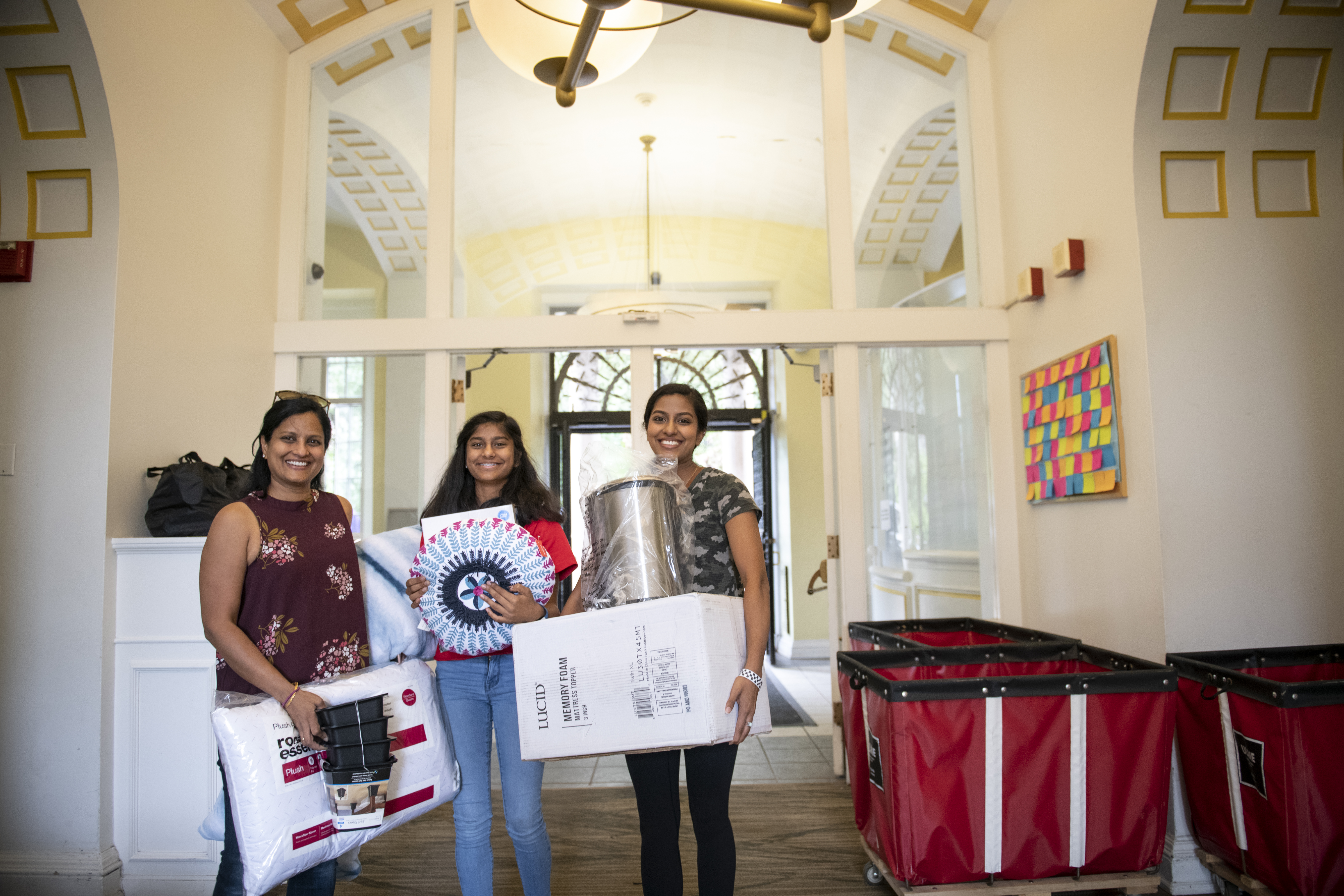 Photo of a mother and two students moving into Mudge Hall