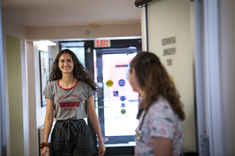 photo of student walking into University Health Services to be seen during an appointment