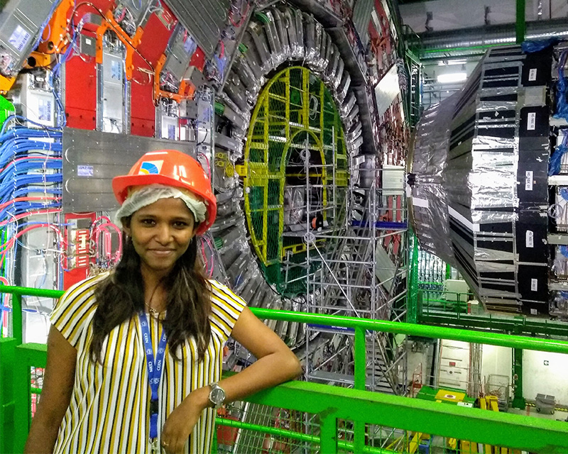 Abhirami Harilal stands in front of equipment at CERN.