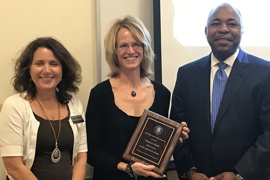 image of kim Sestili accepting the award with Michelle Piekutowski and Rodney McClendon