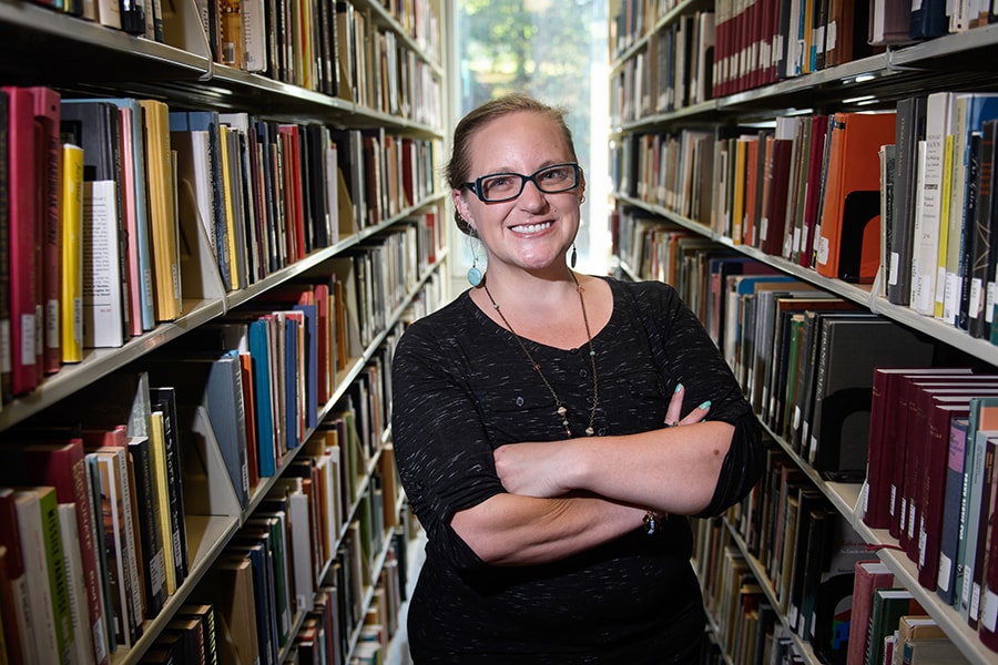 portrait of Lindsey Shultz between book cases in the library