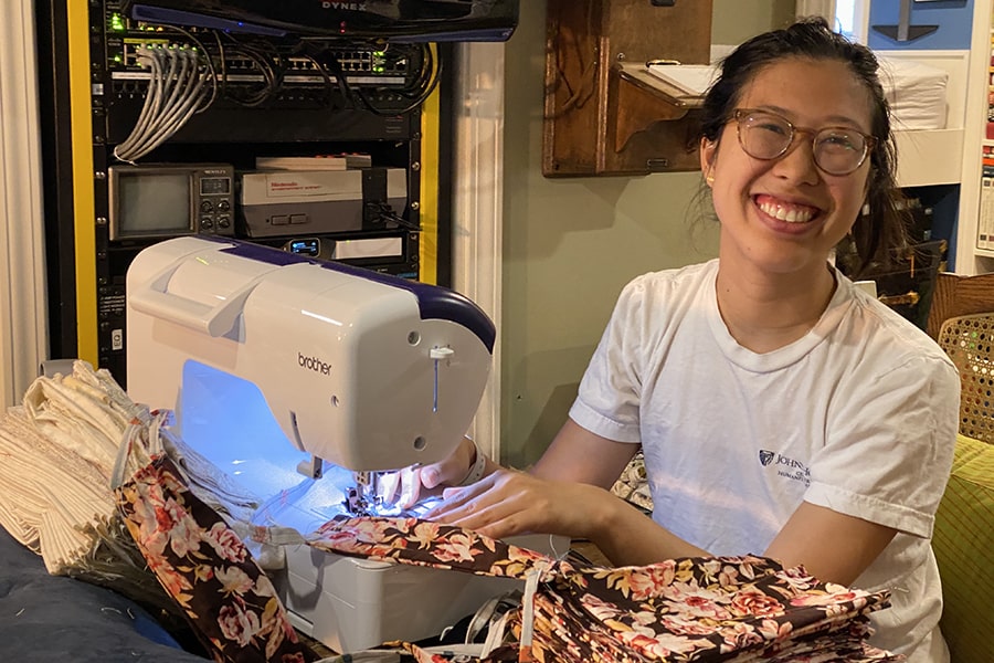 image of Angela Ng at the sewing machine making face mask