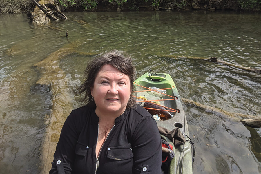 image of Nora Tallmon sitting in kayak on the river