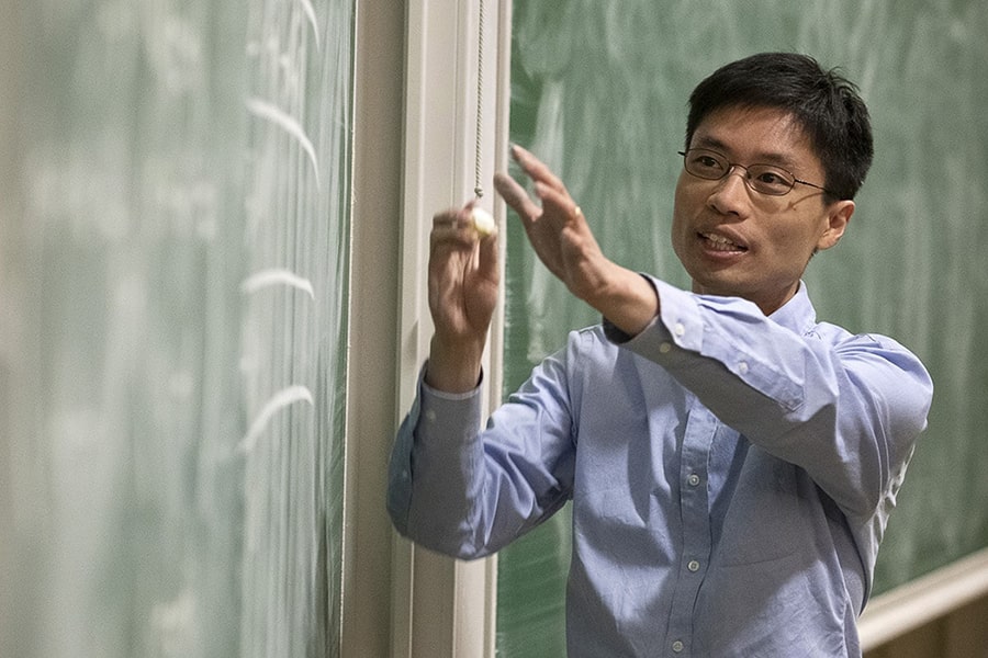 candid image of Po-Shen-Loh teaching at the blackboard