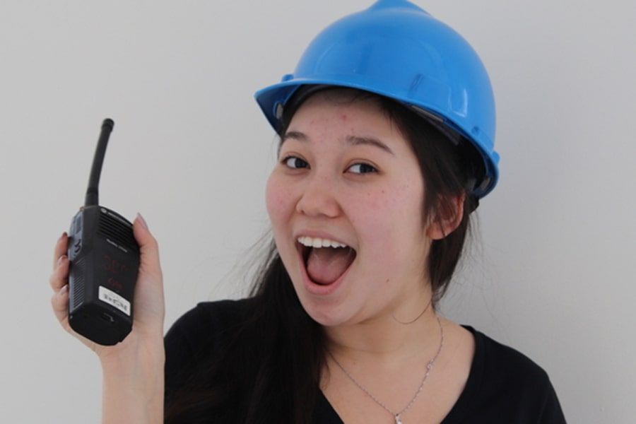 image of Renata Yerzhanova holding a walkie-talkie and waring a hard hat as carnival co-chair