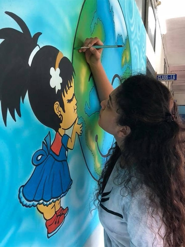 image of Aadya Bhartia painting a picture of a little girl