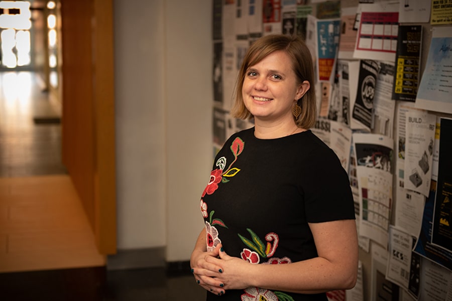 Image of Alexendra Hiniker standing in front of the activities board in the first floor hallway of Cohon Center