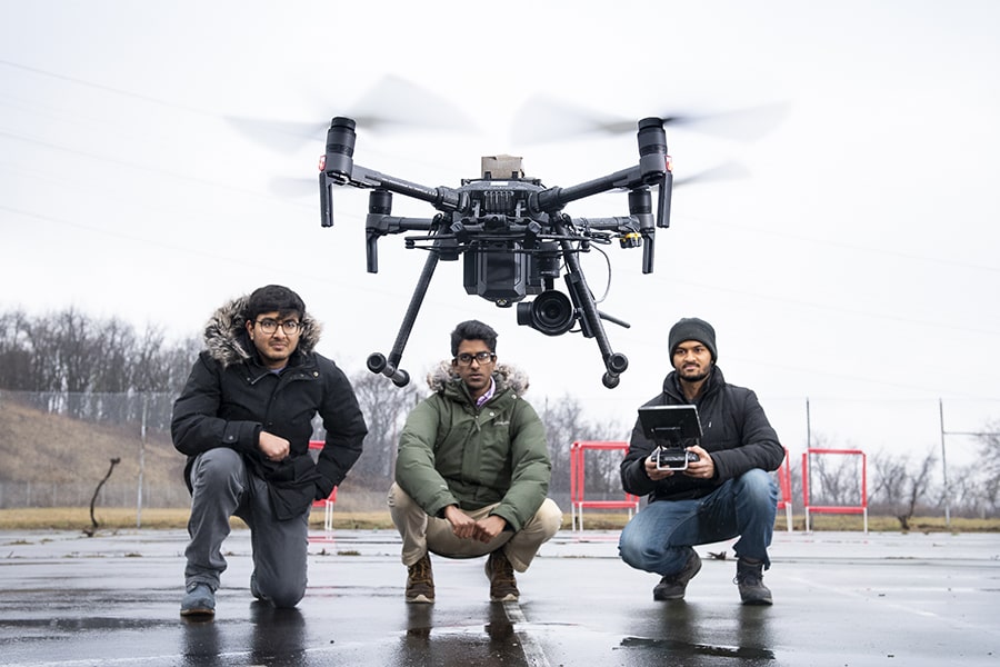 image of the Tartan drone team with a drone above them
