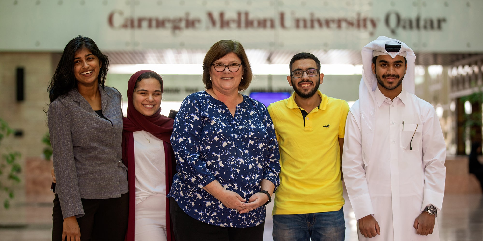 Image of Renee Camerlengo standing with CMU Qatar students