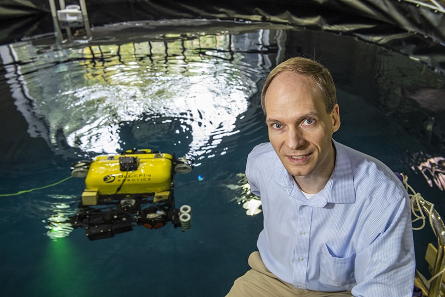 image of Michael Kaess with an autonomous robot in water