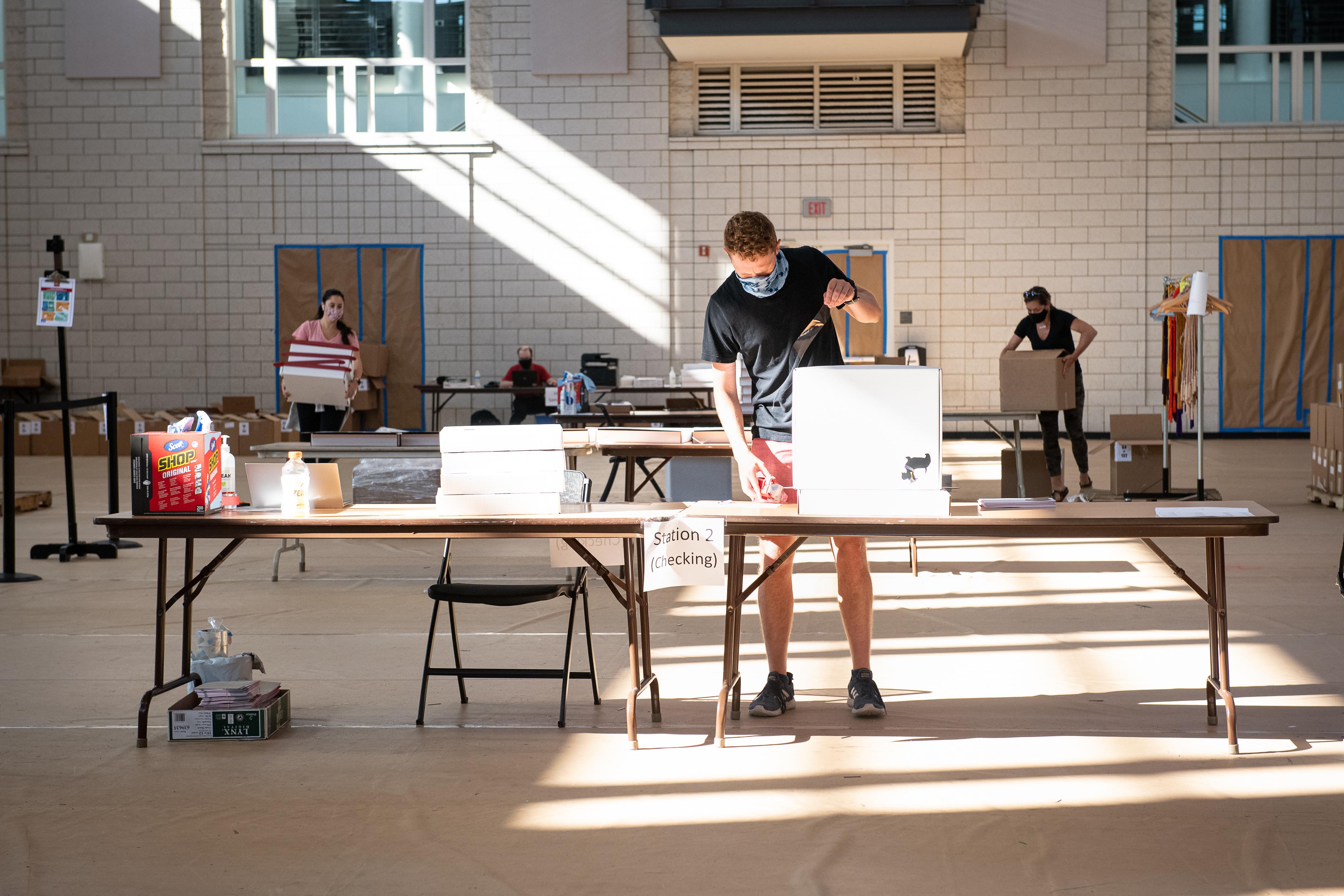 Image of Station 2 where Matt Stephens is assembling boxes on a table