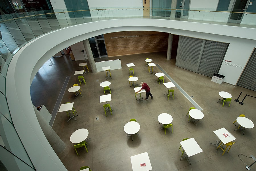 Image of custodian cleaning the tabletops of Rohr Commons