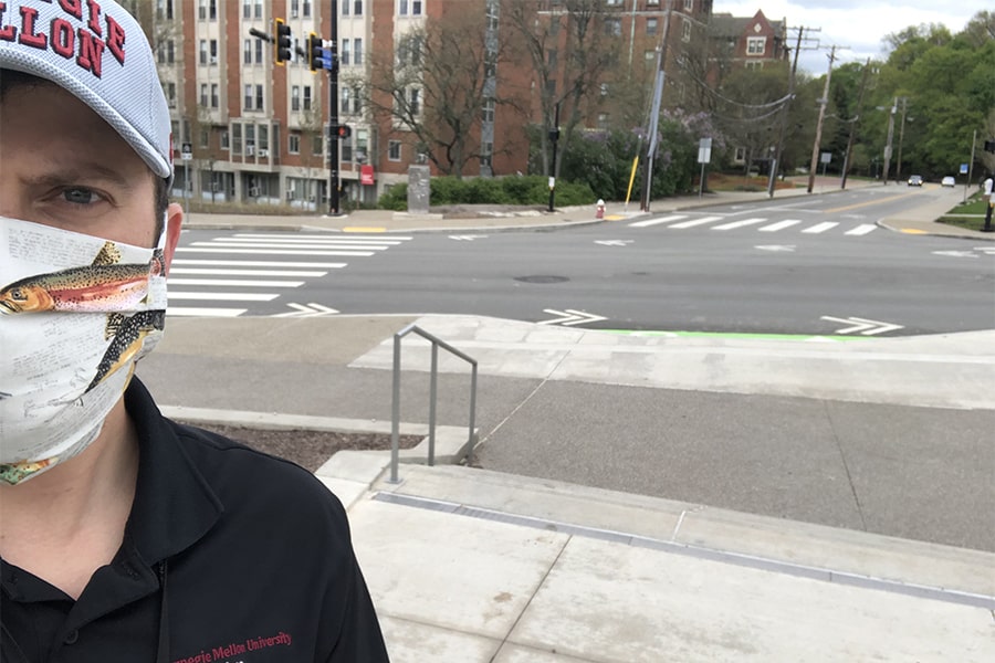 selfie of Cansick wearing mask and showing empty intersection behind him at Morewood and Forbes