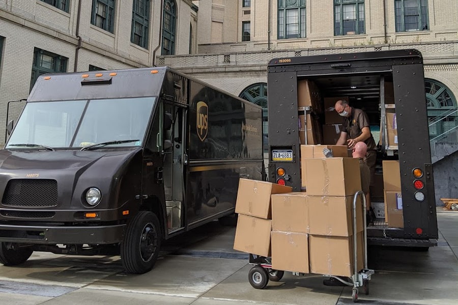 a UPS worker loads his truck with boxes