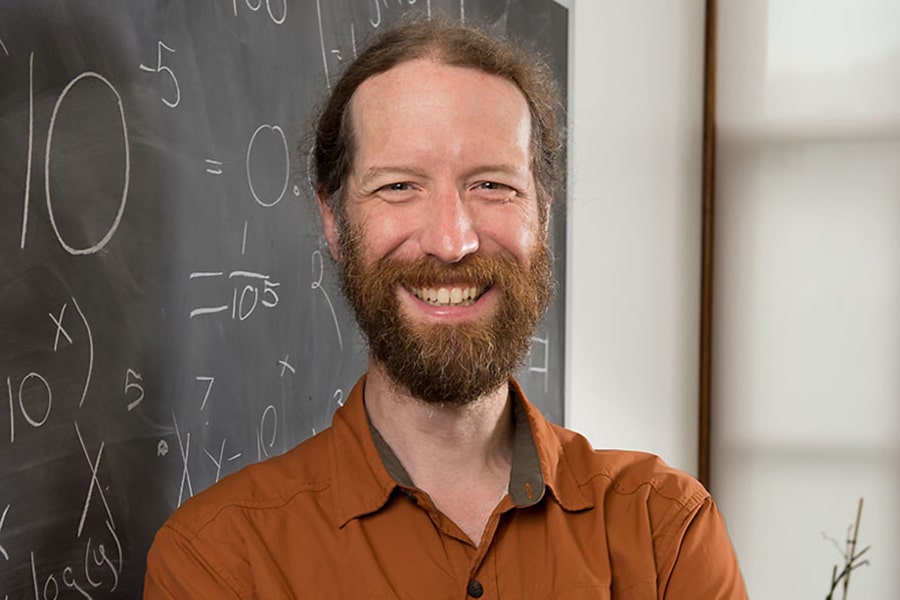 classroom portrait of Neil Donahue in front of a blackboard