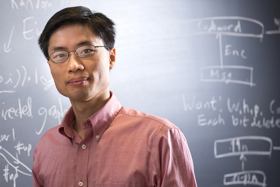 Image of Po-Shen-Loh in front of chalk-written equations on blackboard 