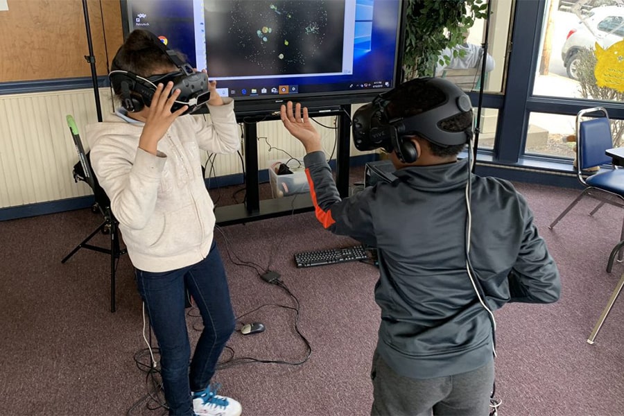 two kids facing each other wearing virtual reality headgear