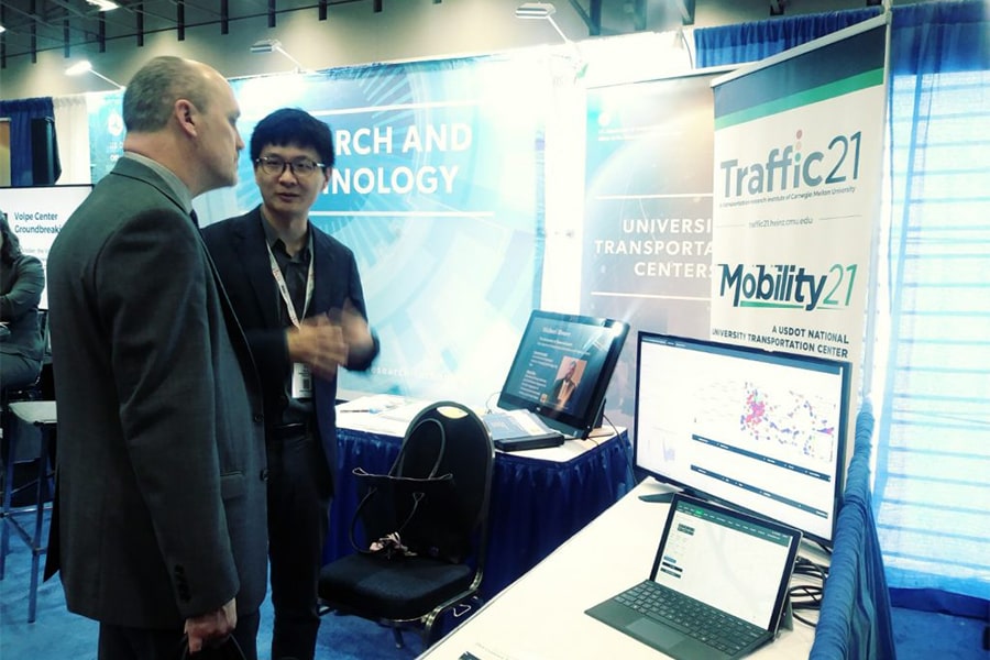two men standing at a booth display for Traffic21