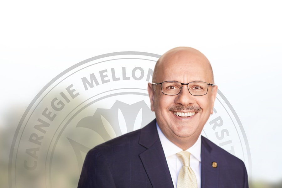 portrait of Farnam Jahanian in front of top half of CMU seal