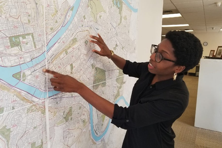woman pointing at locations on a wall map