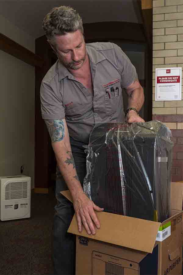 image of laborer pulling purifier out of its box