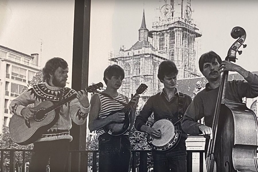 black and white image of Marc De Graef with group of musicians