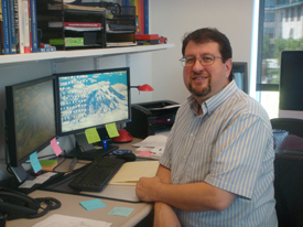 Tom Cortina at his desk in front of his computer monitor