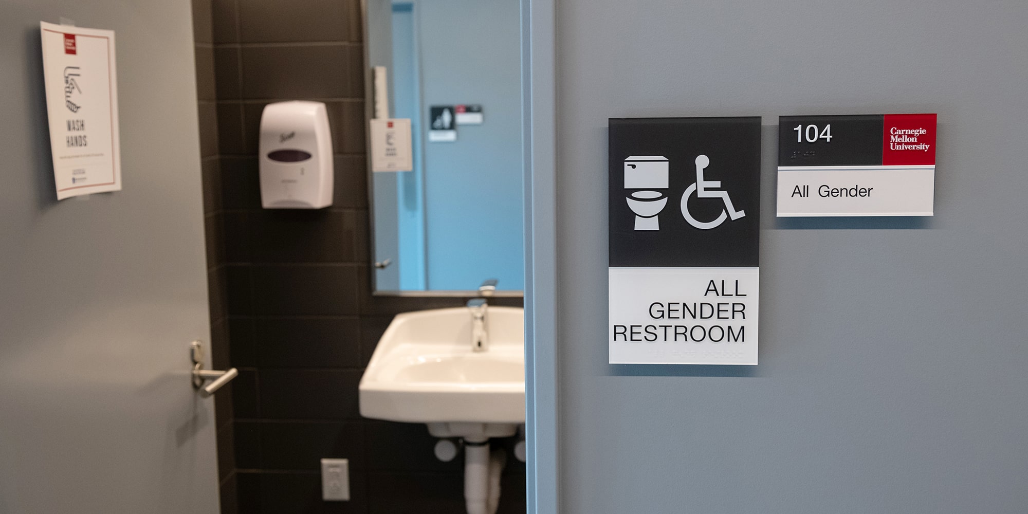 image of all-gender restroom signage outside a CMU restroom