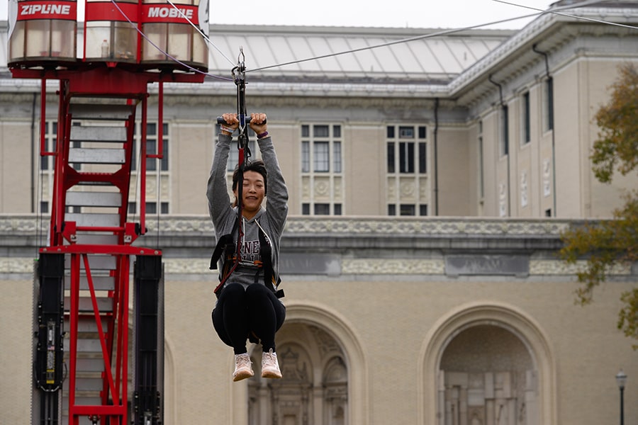 a student rides the zip line in 2019