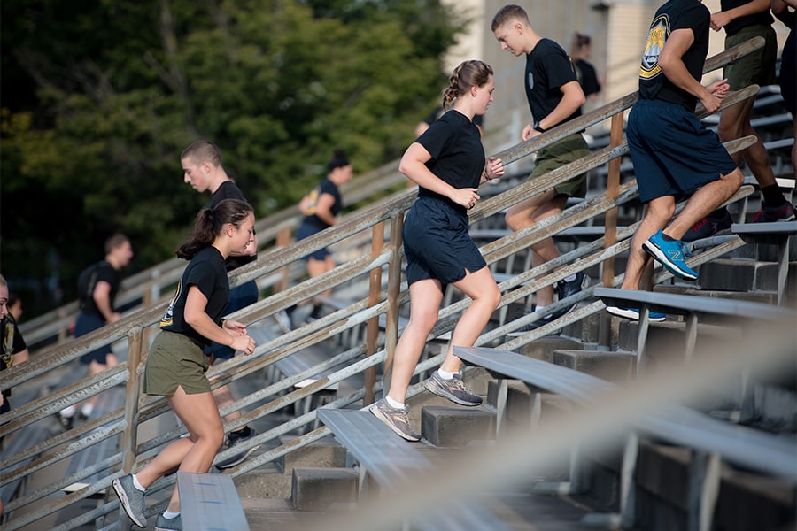 closeup of midshipmen running up the steps of Gesling Stadium
