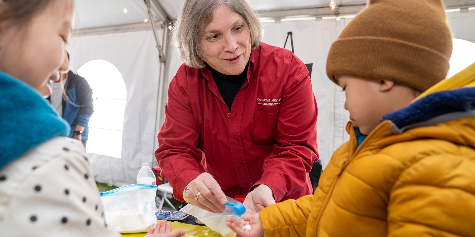 Judy Hallinen works with kids at an activities table during Spring Carnival