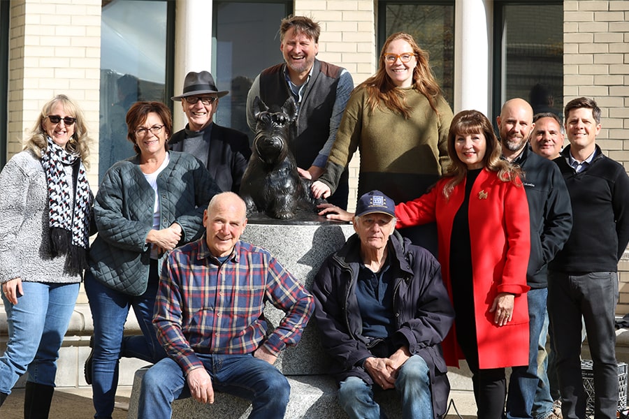 Image of group involved with installation standing around Scotty Sculpture