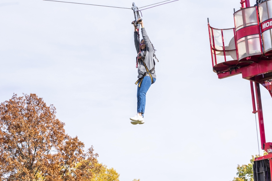 a student rides the zip line