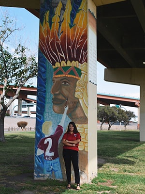 Morales standing in front of mural in El Paso