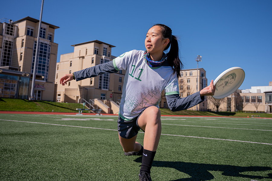 Sara Liang kneels to throw frisbee