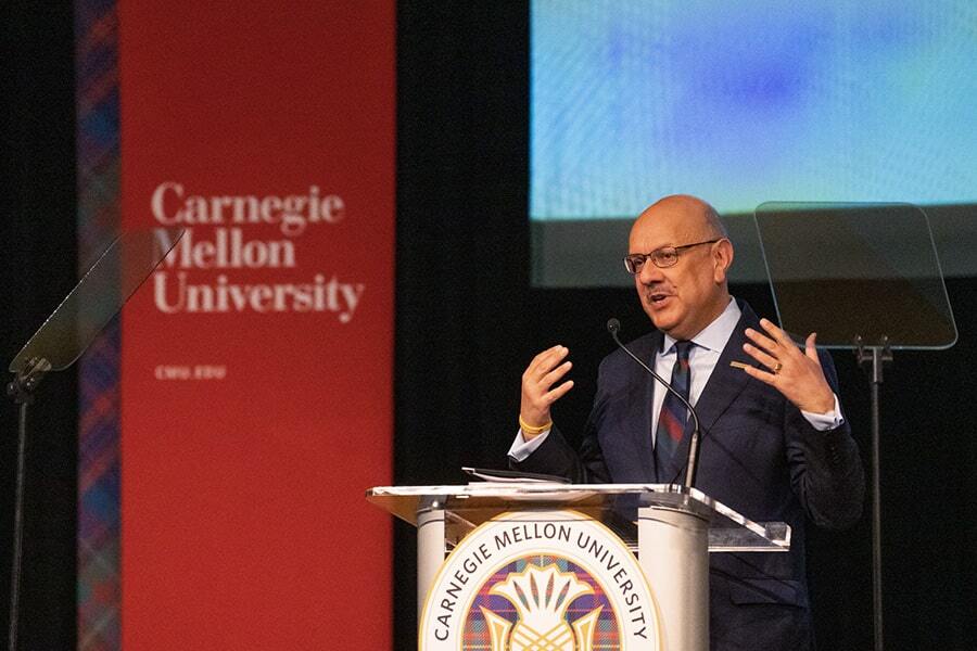 CMU President Farnam Jahanian on stage behind podium