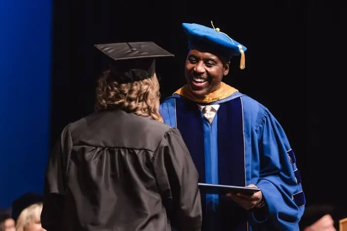 Larry Pickett awarding a diploma to a graduating student at Clarion University.