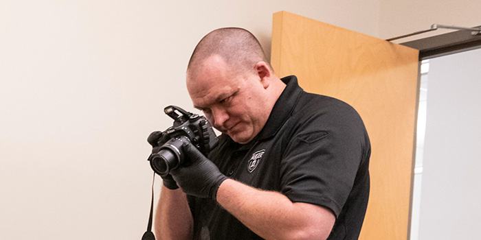 CMU police officer photographing crime scene