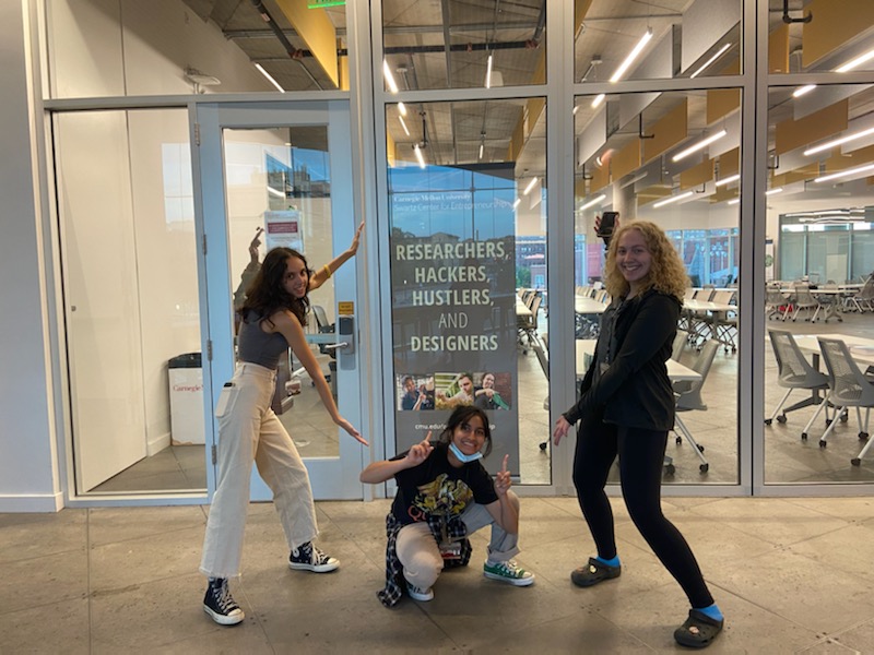 Pre-College students pointing at tech poster.